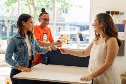Students show their PacificCard to a Miracle Mile merchant